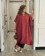Woman in a red dress standing in a hallway