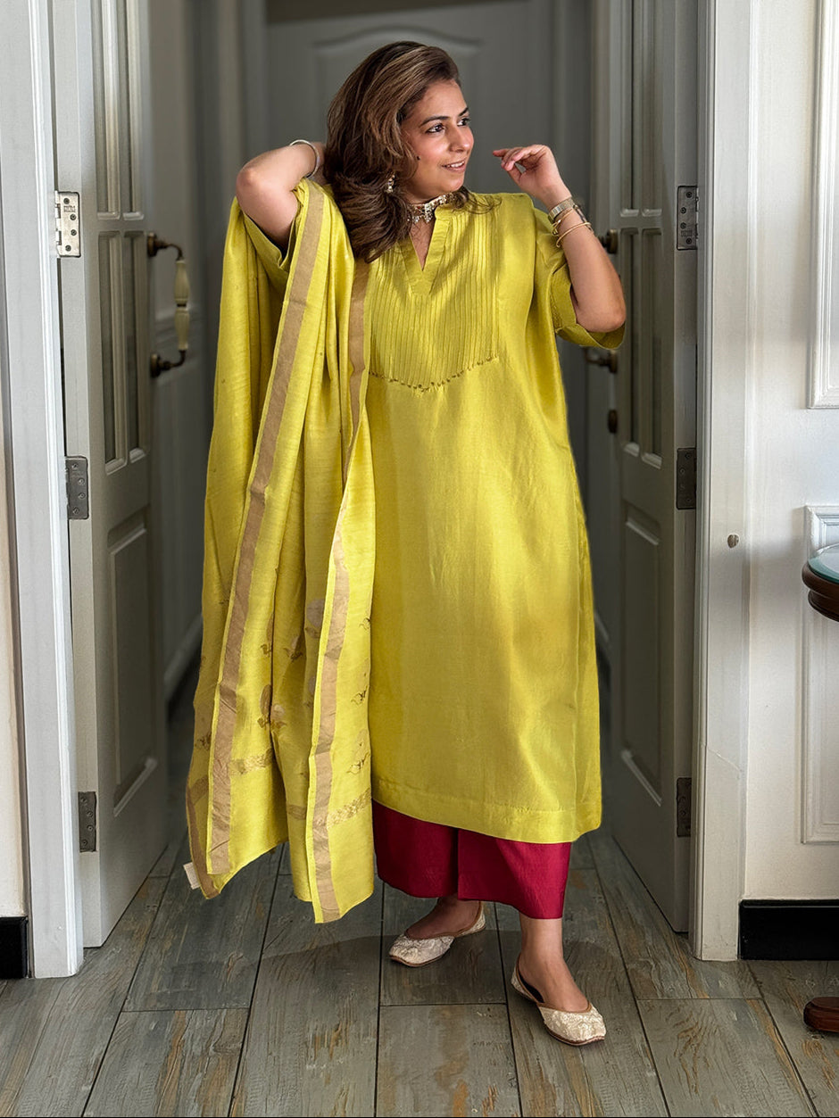 Woman in a yellow outfit standing in a hallway