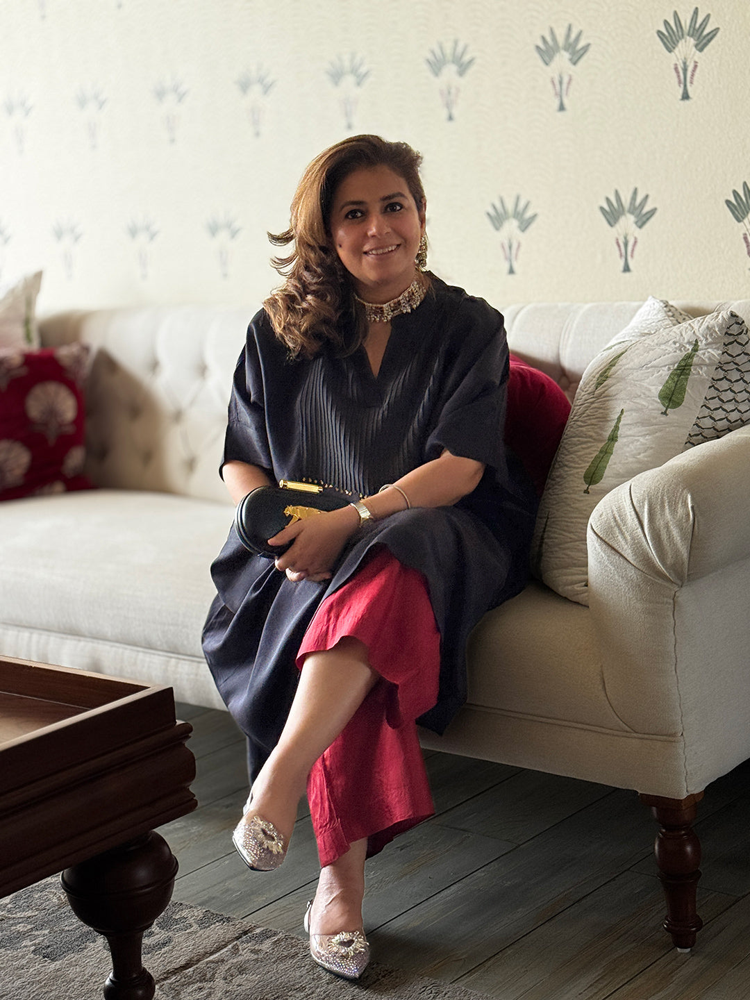 Woman sitting on a couch in a living room with decorative pillows and a coffee table.