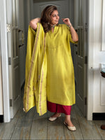 Woman in a yellow outfit standing in a hallway