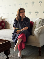 Woman sitting on a couch in a living room with decorative pillows and a coffee table.
