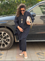 Woman in a navy outfit standing next to a Mercedes GLC 300 car with greenery in the background